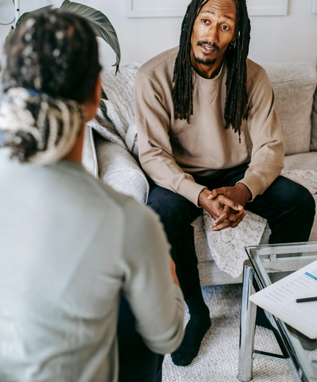 Man sitting on a couch and talking to a therapist