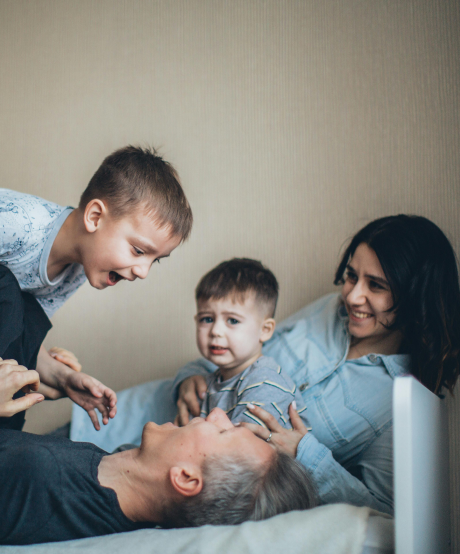 Young family playing on a bed Young family playing on a bed