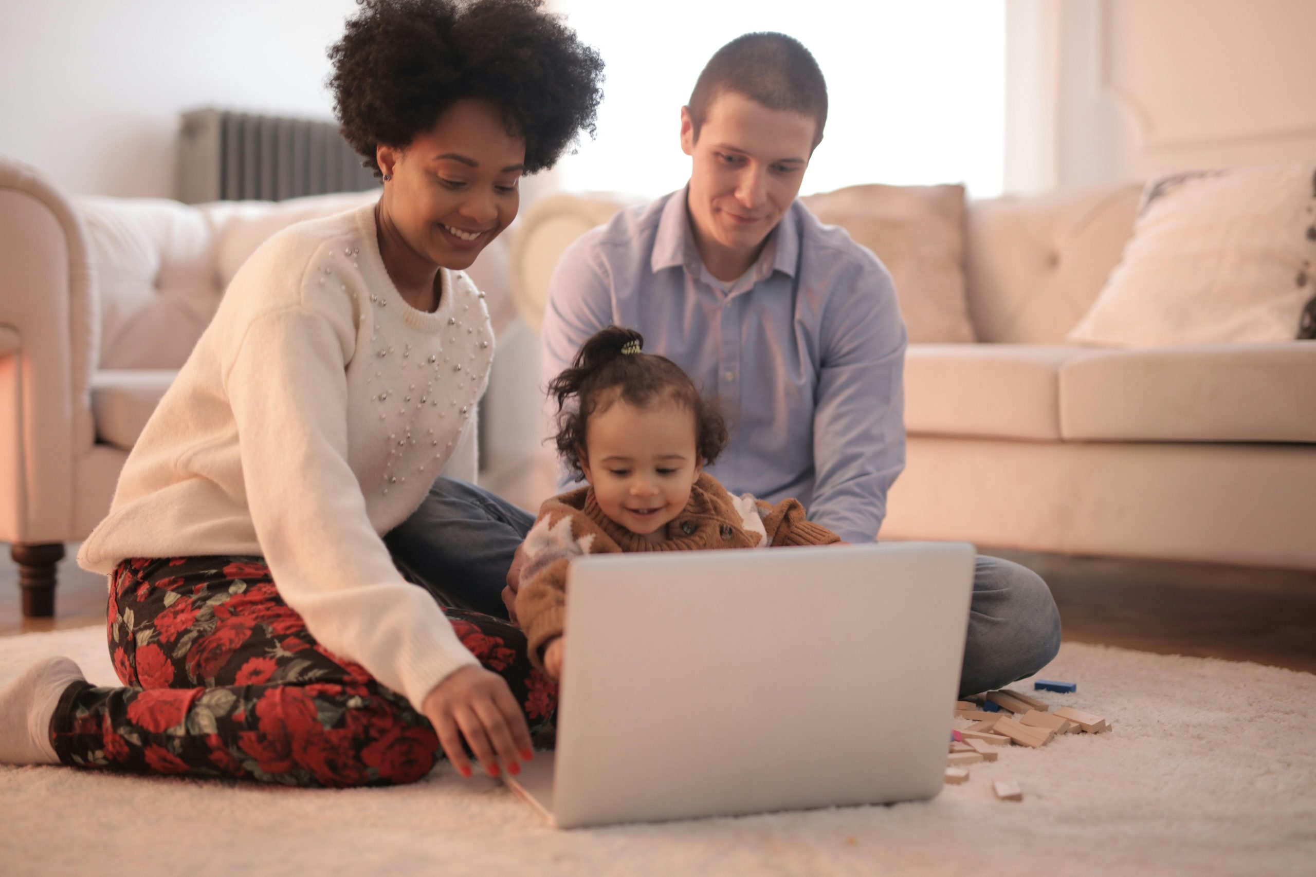 Mother and father playing with toddler on a computer Mother and father playing with toddler on a computer